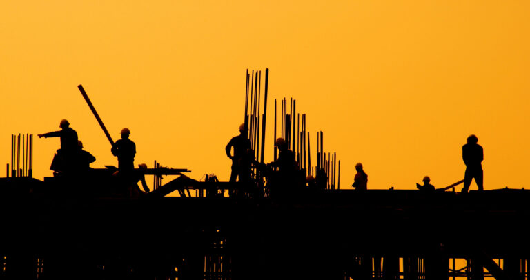 Construction workers at sunset